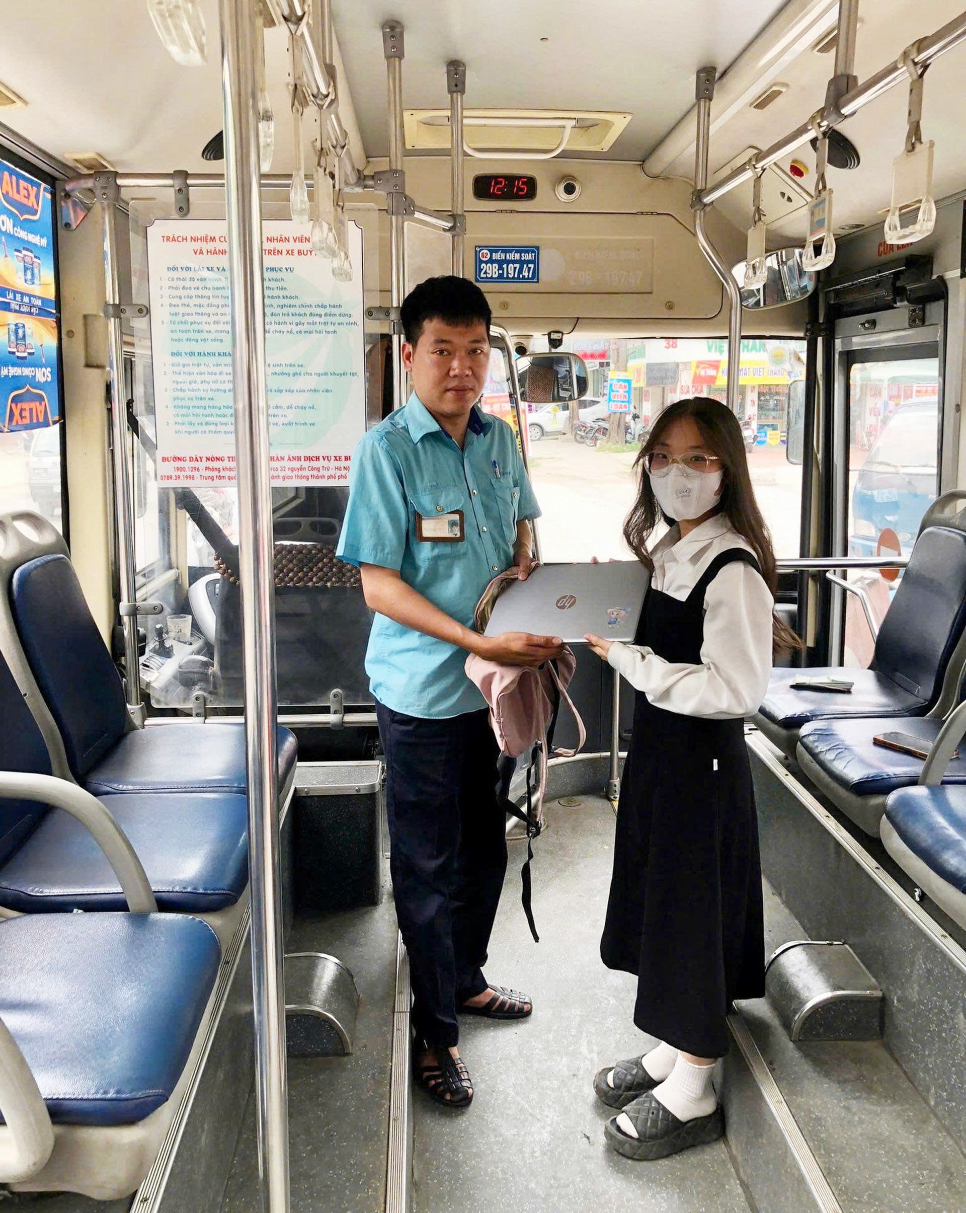 Nhân viên bán vé trả lại ba lô cho hành khách.